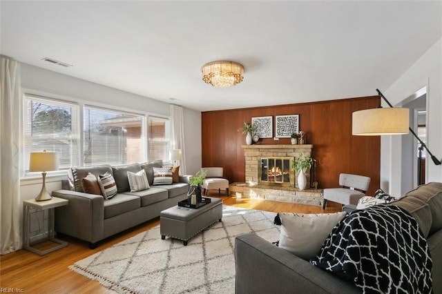 living room featuring a fireplace, wooden walls, and hardwood / wood-style floors