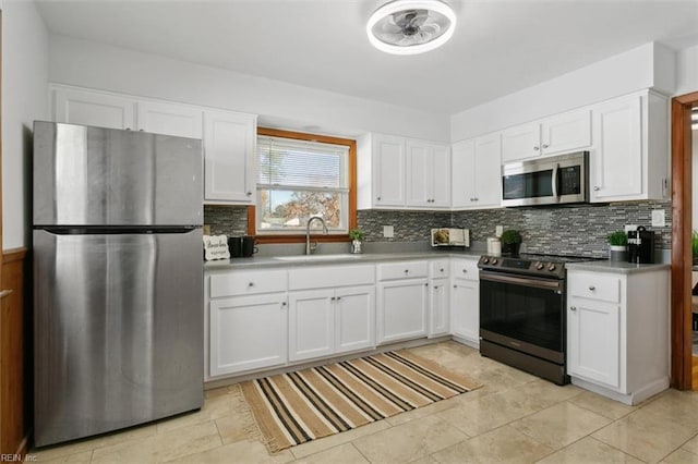 kitchen with appliances with stainless steel finishes, backsplash, white cabinetry, and sink