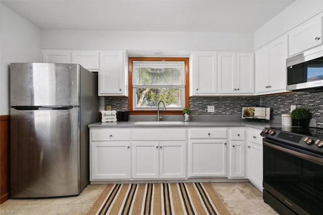 kitchen featuring backsplash, white cabinetry, sink, and appliances with stainless steel finishes