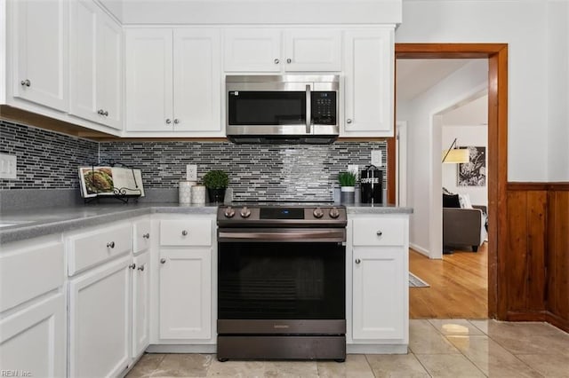 kitchen featuring decorative backsplash, white cabinetry, and appliances with stainless steel finishes