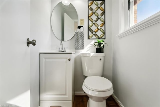 bathroom with hardwood / wood-style floors, vanity, and toilet