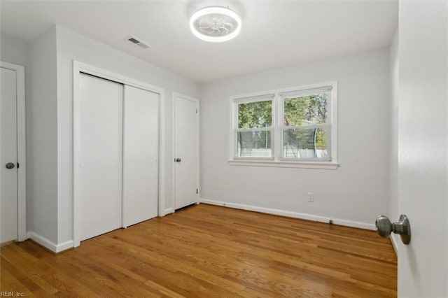 unfurnished bedroom with a closet and hardwood / wood-style flooring