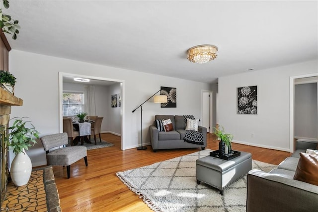 living room with hardwood / wood-style floors and an inviting chandelier