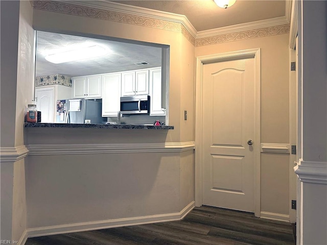 kitchen featuring white cabinets, stainless steel appliances, kitchen peninsula, and dark hardwood / wood-style floors