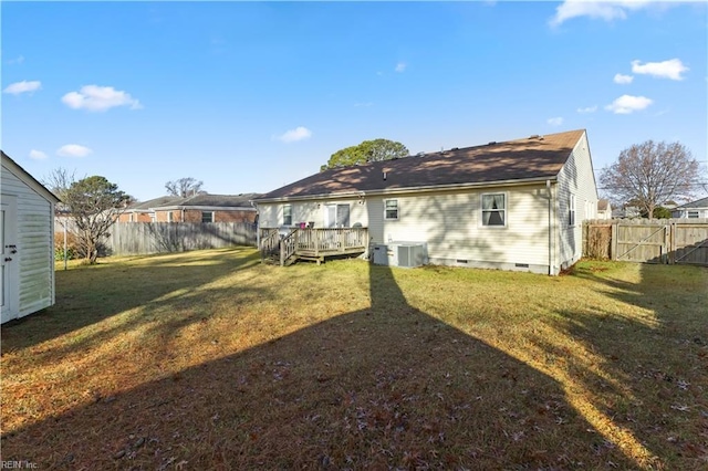 rear view of house with a lawn, a wooden deck, and central AC unit