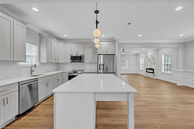 kitchen featuring sink, appliances with stainless steel finishes, a center island, and tasteful backsplash