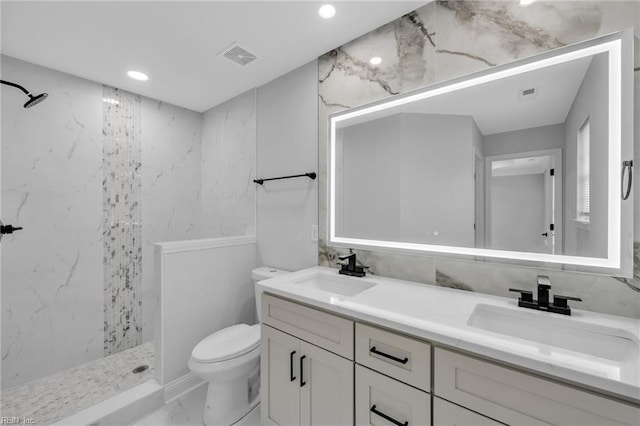 bathroom featuring tiled shower, vanity, and toilet