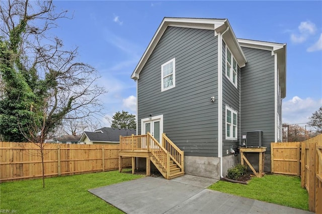 back of house featuring a patio area, a lawn, and french doors