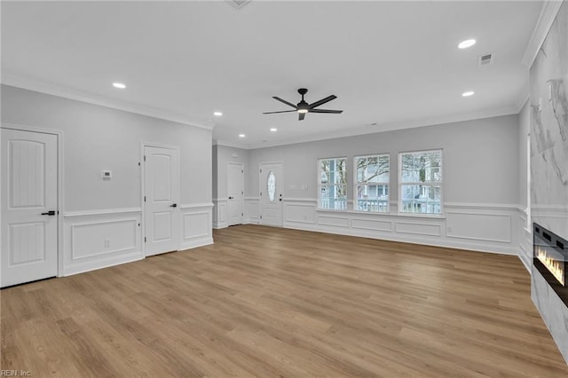 unfurnished living room featuring ceiling fan, light wood-type flooring, and ornamental molding