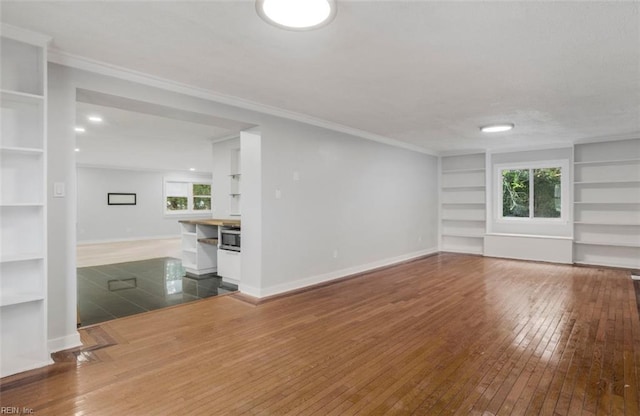 unfurnished living room featuring hardwood / wood-style flooring and built in features