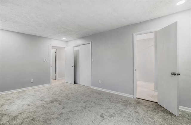 carpeted empty room with a textured ceiling