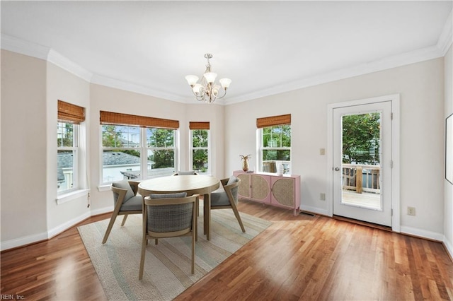 dining area featuring hardwood / wood-style flooring, crown molding, and a chandelier