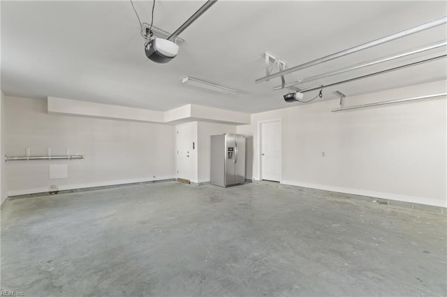 garage featuring a garage door opener and stainless steel refrigerator with ice dispenser