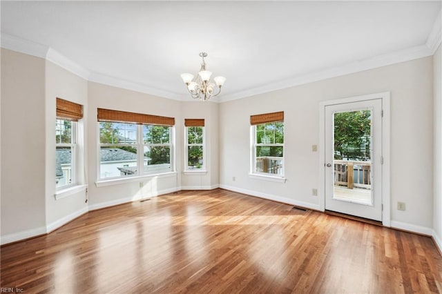 unfurnished room featuring crown molding, a chandelier, and wood-type flooring