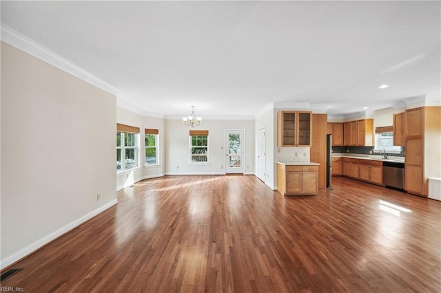 unfurnished living room with sink, wood-type flooring, ornamental molding, and a chandelier