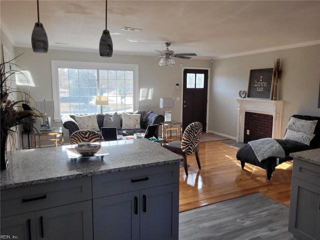 kitchen with a wealth of natural light, ceiling fan, decorative light fixtures, and light wood-type flooring