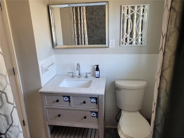 bathroom featuring vanity, tile walls, and toilet