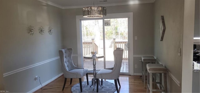 dining room with crown molding, hardwood / wood-style floors, and an inviting chandelier