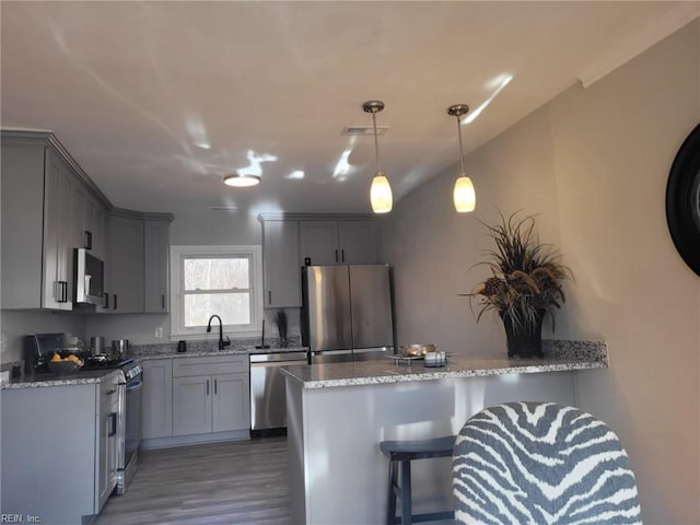 kitchen featuring light stone countertops, appliances with stainless steel finishes, gray cabinetry, and sink