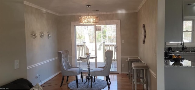 dining space with hardwood / wood-style floors, plenty of natural light, and crown molding