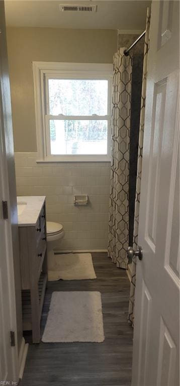 bathroom featuring a shower with curtain, vanity, hardwood / wood-style flooring, tile walls, and toilet