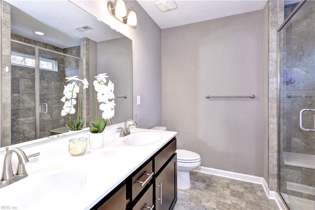 bathroom with a textured ceiling, vanity, toilet, and an enclosed shower