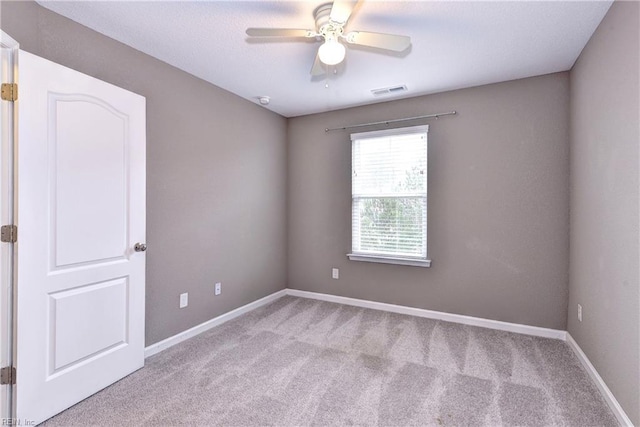 empty room featuring light carpet and ceiling fan