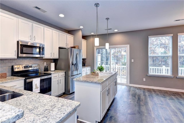 kitchen with white cabinetry, light stone countertops, dark wood-type flooring, pendant lighting, and appliances with stainless steel finishes