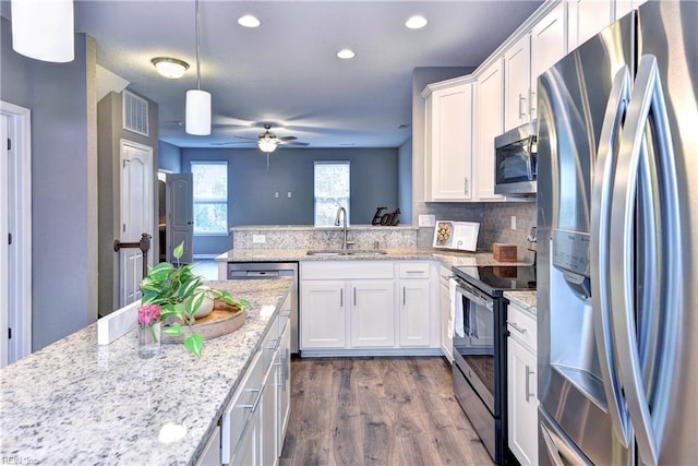 kitchen featuring white cabinets, decorative light fixtures, sink, and stainless steel appliances