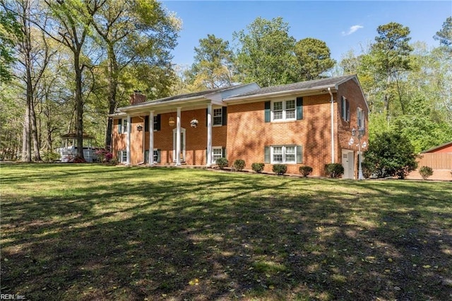 raised ranch featuring a garage and a front yard