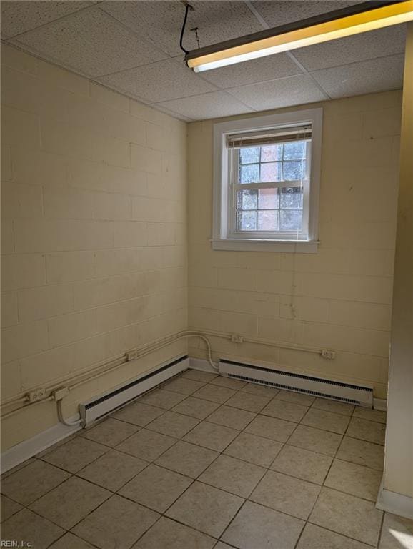 empty room with a baseboard radiator and a paneled ceiling