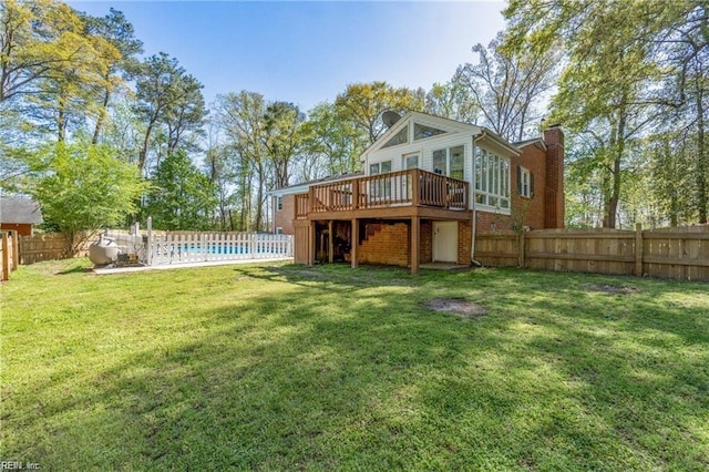 rear view of house with a yard and a swimming pool side deck