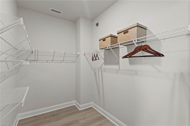 walk in closet with hardwood / wood-style floors