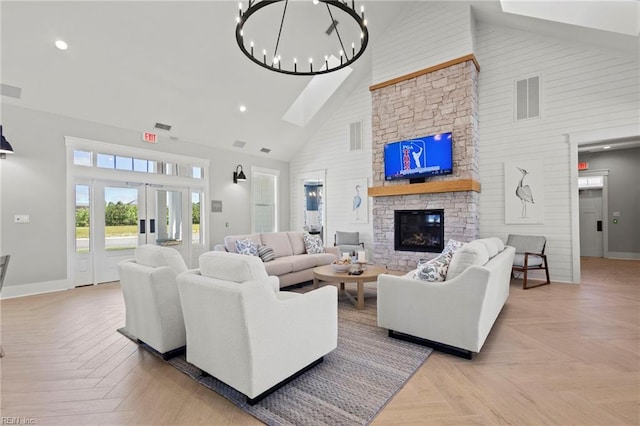 living room featuring french doors, light parquet floors, high vaulted ceiling, a notable chandelier, and a fireplace