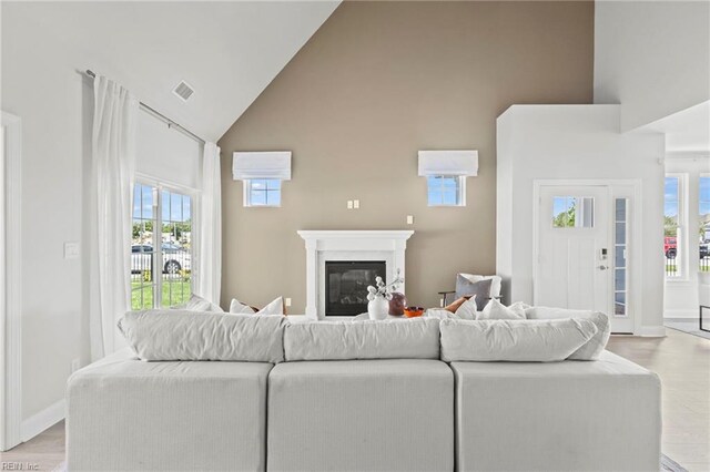 living room with high vaulted ceiling and light hardwood / wood-style flooring