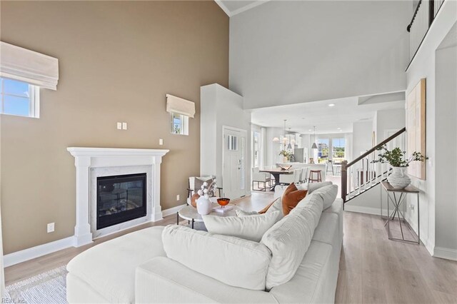 living room featuring light wood-type flooring and a towering ceiling