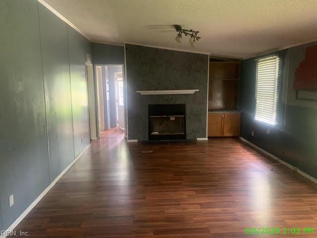 105 Chambliss Rd, Emporia, VA 23847 - unfurnished living room featuring dark wood-style floors, a large fireplace, baseboards, a textured ceiling, and lofted ceiling