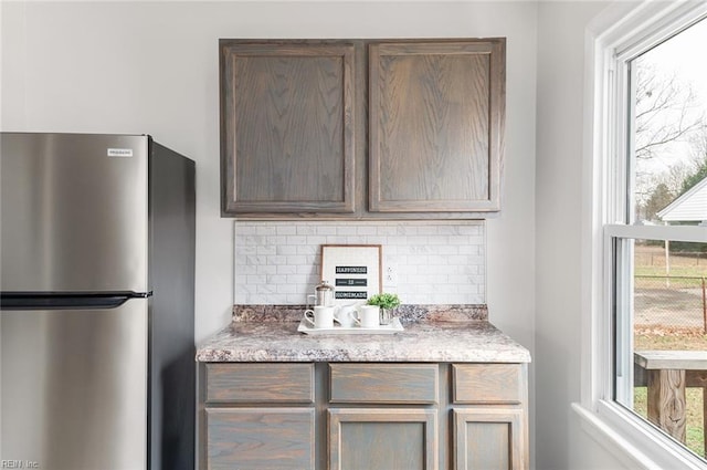 kitchen with stainless steel refrigerator and tasteful backsplash