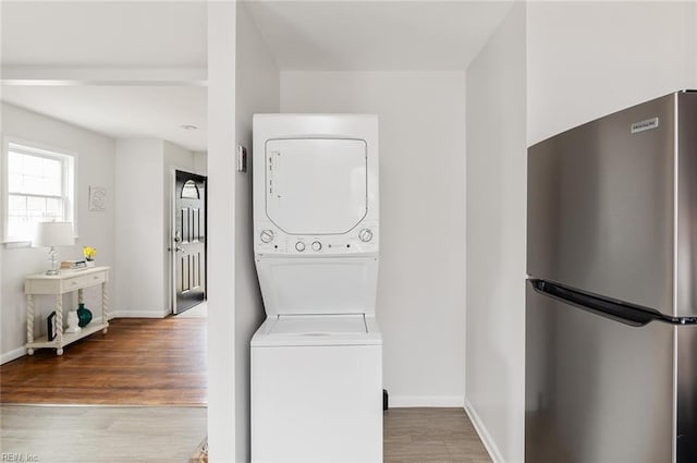 washroom featuring light hardwood / wood-style floors and stacked washer and dryer