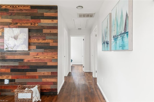 corridor with wooden walls and dark wood-type flooring