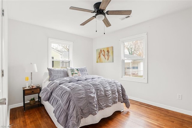 bedroom with dark hardwood / wood-style flooring and ceiling fan