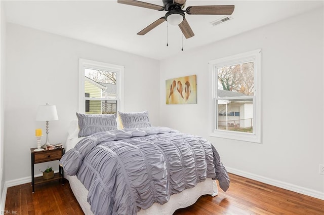 bedroom with dark hardwood / wood-style floors, multiple windows, and ceiling fan