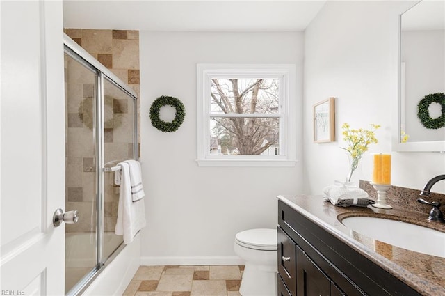 full bathroom featuring combined bath / shower with glass door, vanity, and toilet