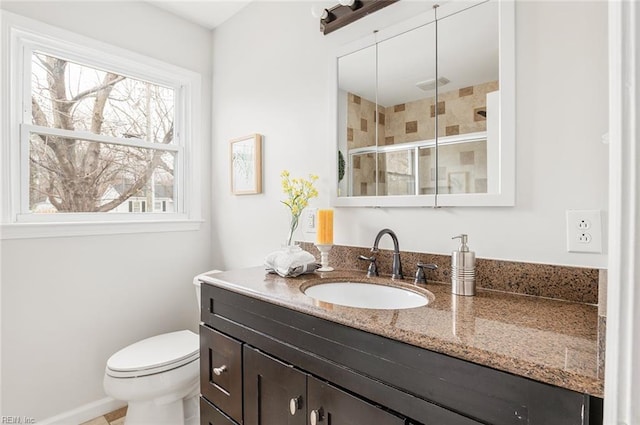 bathroom with vanity, toilet, and walk in shower