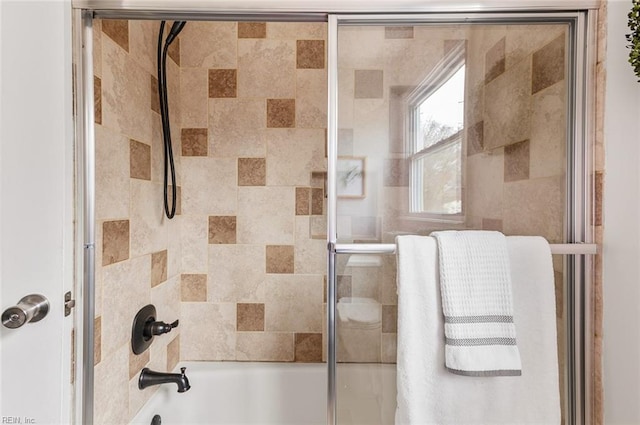 bathroom featuring bath / shower combo with glass door