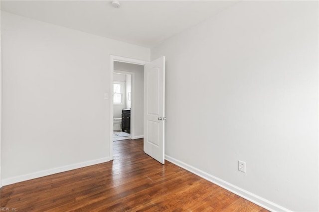 empty room with dark hardwood / wood-style flooring