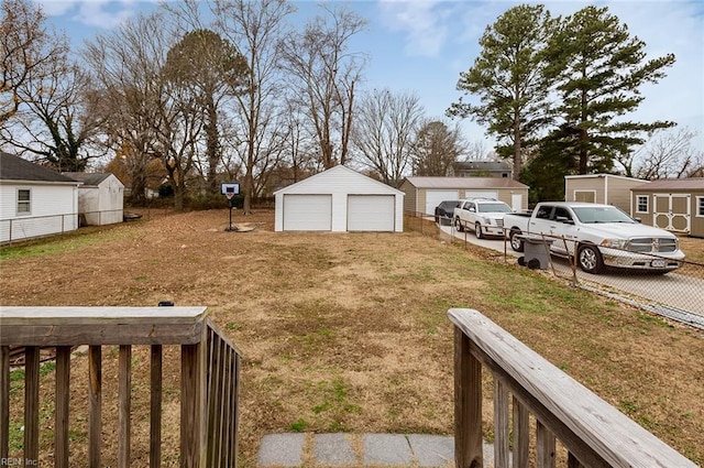 view of yard with a garage and an outbuilding