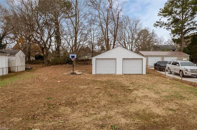 view of yard featuring a garage and an outbuilding