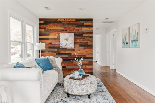 living area with hardwood / wood-style flooring and wood walls