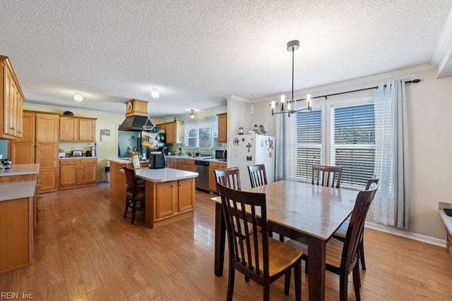 dining area featuring plenty of natural light, ornamental molding, and light hardwood / wood-style flooring